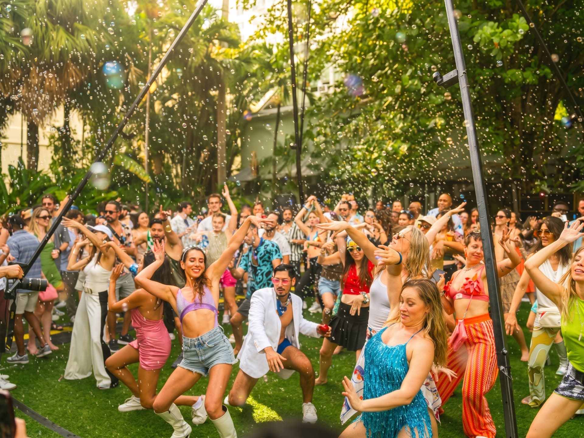 Season 1 dancers celebrating beneath a cloud of sunlit bubbles