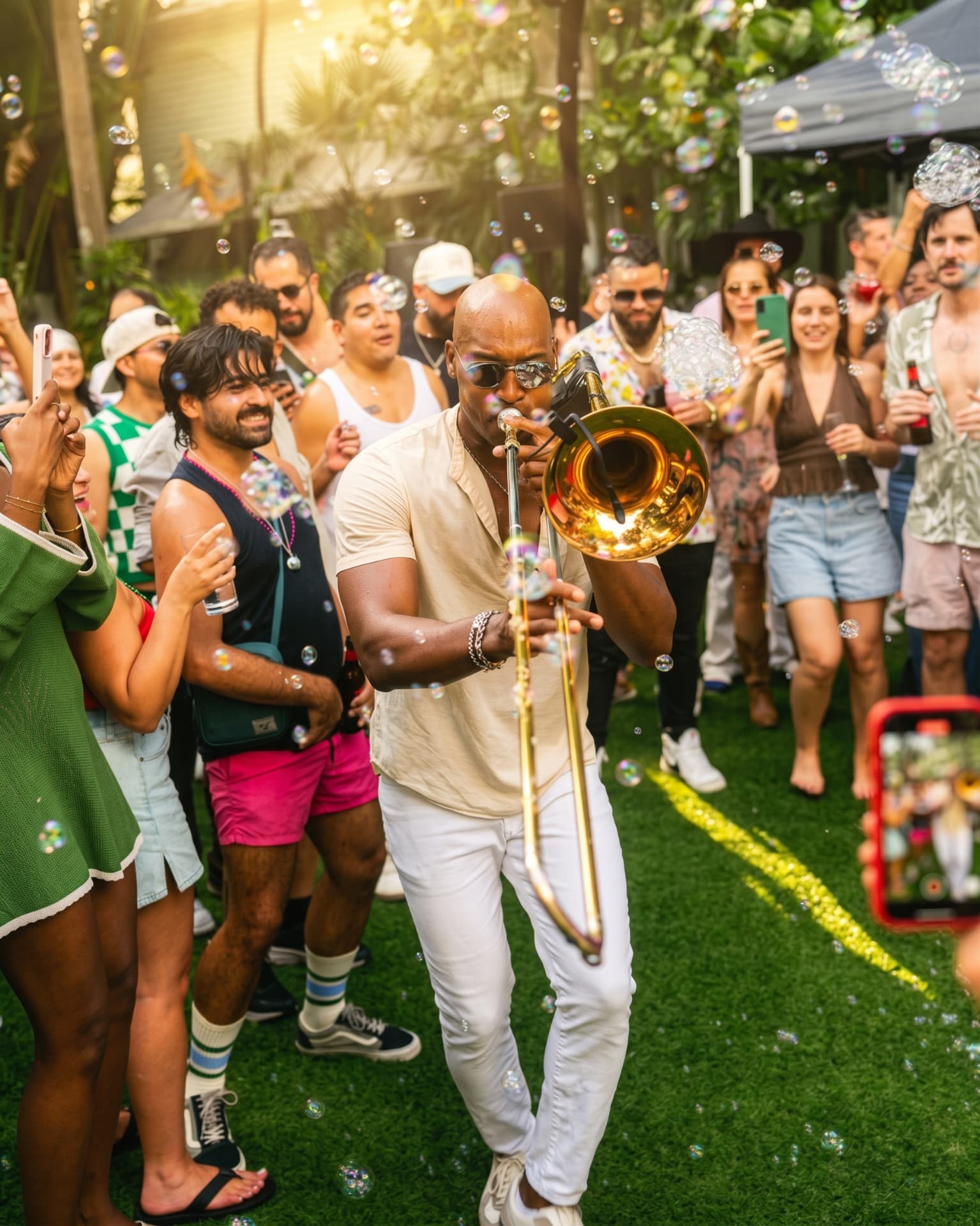 A trombone player performing among bubbles and dancing guests at Season 1